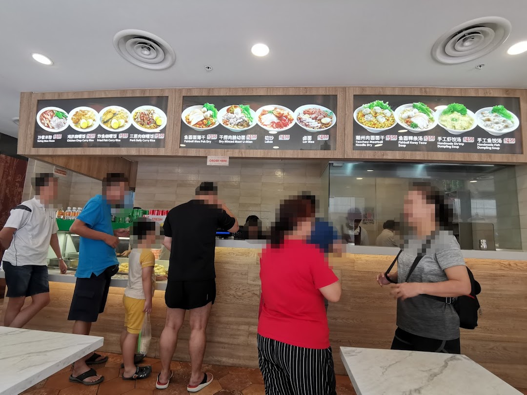 Customers queue at a bustling food stall with digital menu boards displaying various Asian dishes.
