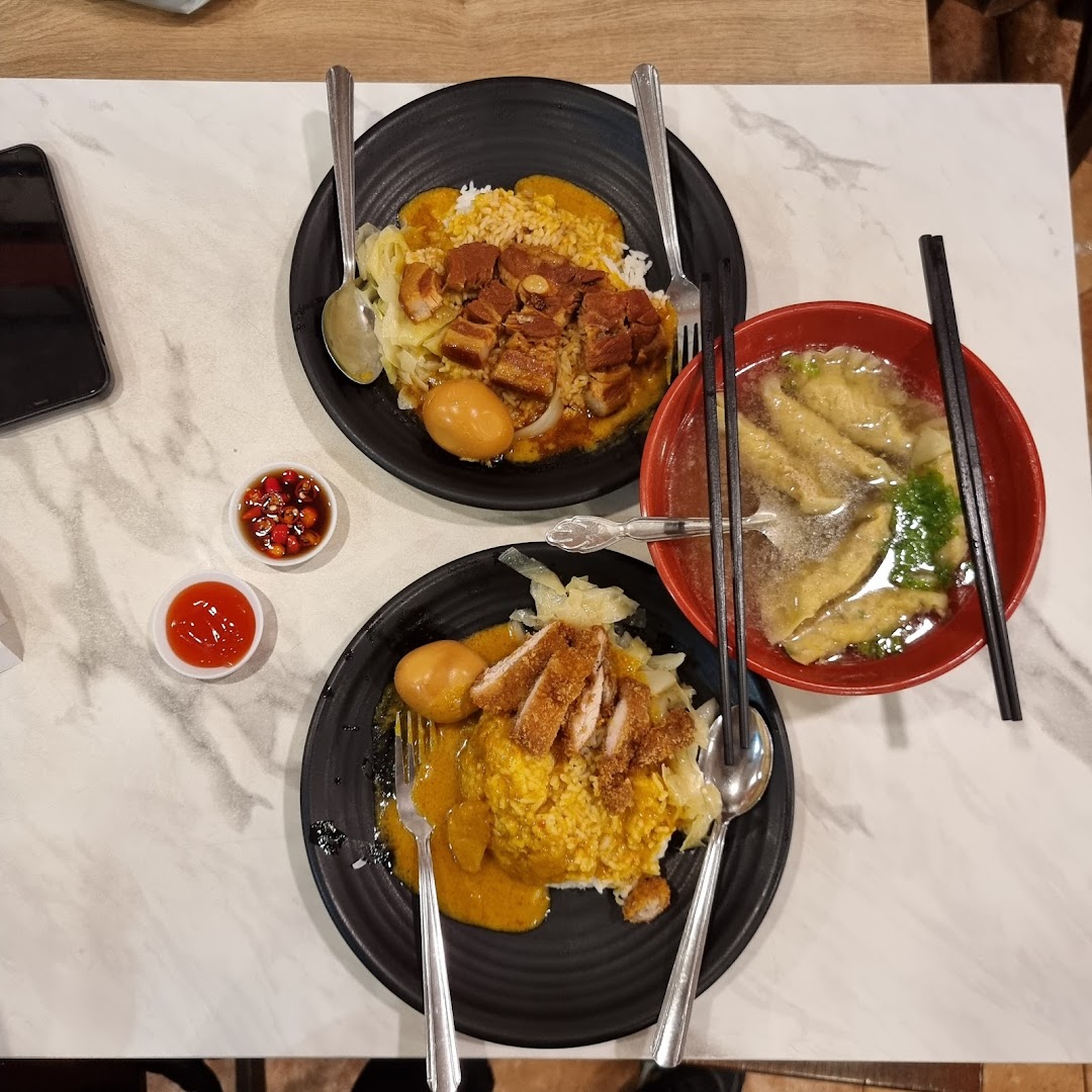 Two plates of delicious curry rice with meat and eggs, alongside a comforting bowl of soup.