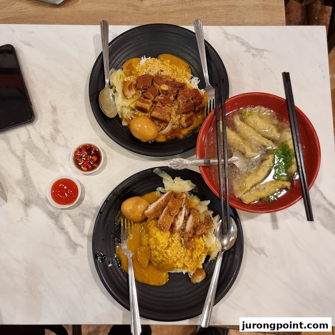 Two plates of delicious curry rice with meat and eggs, alongside a comforting bowl of soup.
