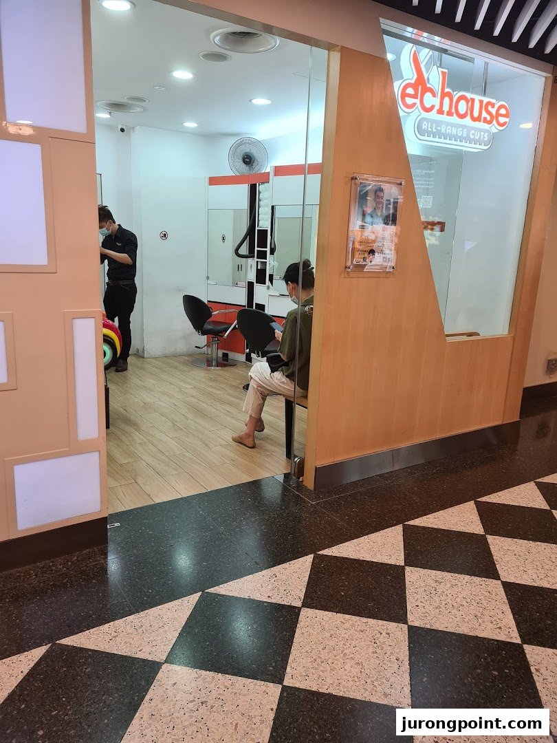 EC House hair salon entrance with customers and staff inside, featuring its 'All-Range Cuts' sign.