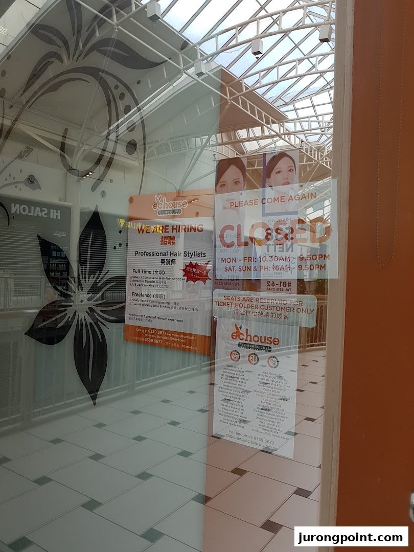The glass entrance of EC House hair salon, displaying hiring signs, operating hours, and customer information.