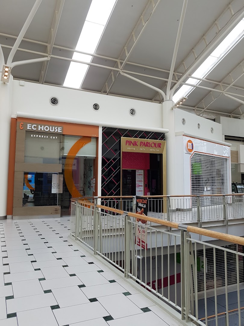 View of EC House Express Cut and Pink Parlour storefronts inside a bright shopping mall.