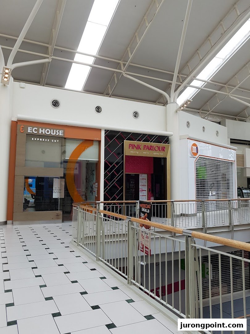 View of EC House Express Cut and Pink Parlour storefronts inside a bright shopping mall.