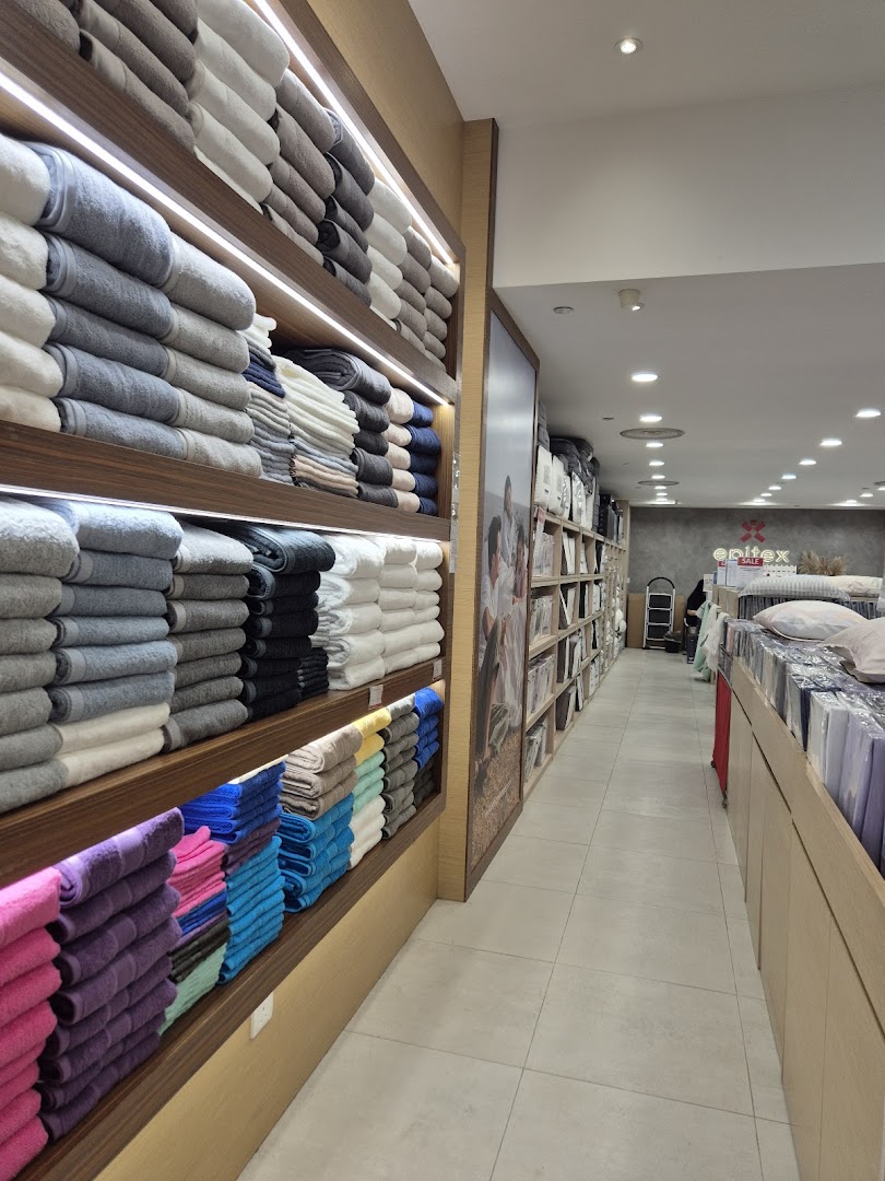 An interior view of Epitex, showcasing neatly stacked towels and various home textile products on display.