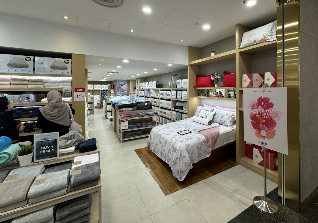 Interior view of Epitex, a home linen store, showcasing bedding, towels, and sale items.