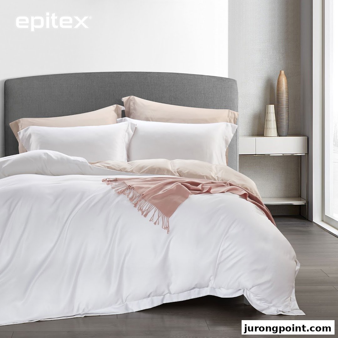 A beautifully made bed featuring white and beige bedding with a pink throw, showcasing Epitex products.