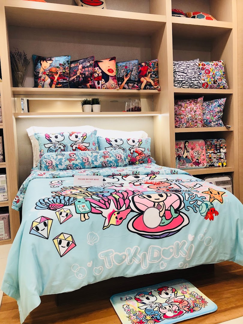 A vibrant Tokidoki-themed bed set with matching cushions displayed in a retail setting.