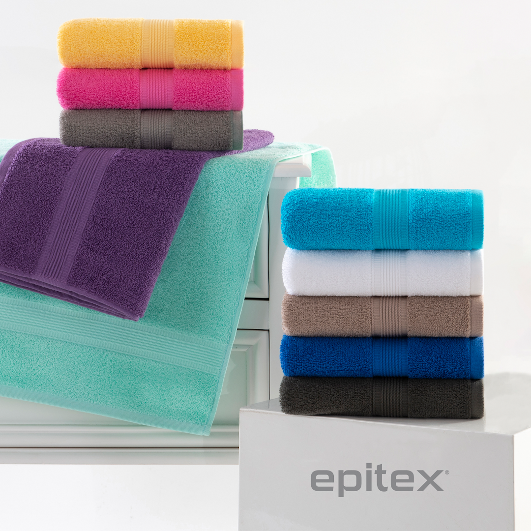 Colorful stacks of soft towels are displayed, showcasing various vibrant shades.