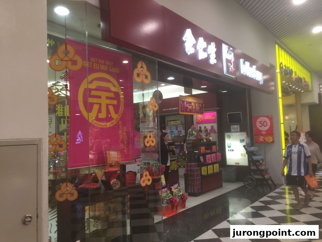 The storefront of Eu Yan Sang, featuring promotional banners and health supplements displays.