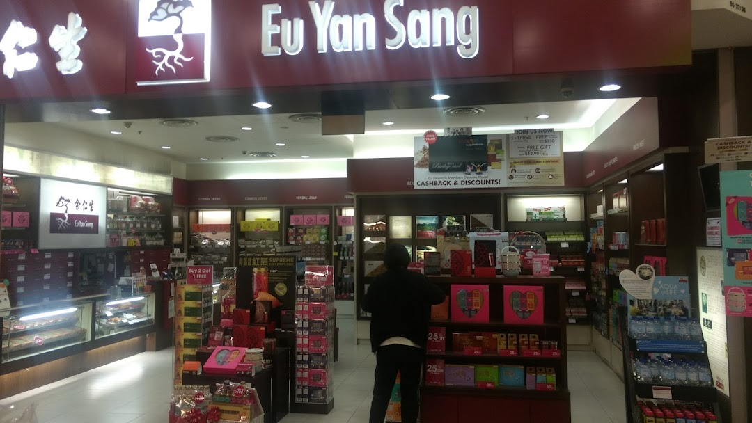 A customer browses wellness products inside the brightly lit Eu Yan Sang retail store.