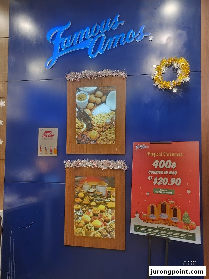 A festive Famous Amos wall display featuring the brand logo, product images, and a Christmas cookie promotion.