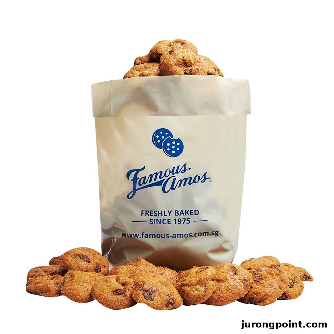 A bag of Famous Amos chocolate chip cookies with more cookies scattered around, highlighting their fresh-baked appeal.