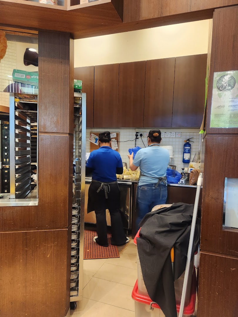 Two staff members are seen preparing products in the kitchen area of Famous Amos.