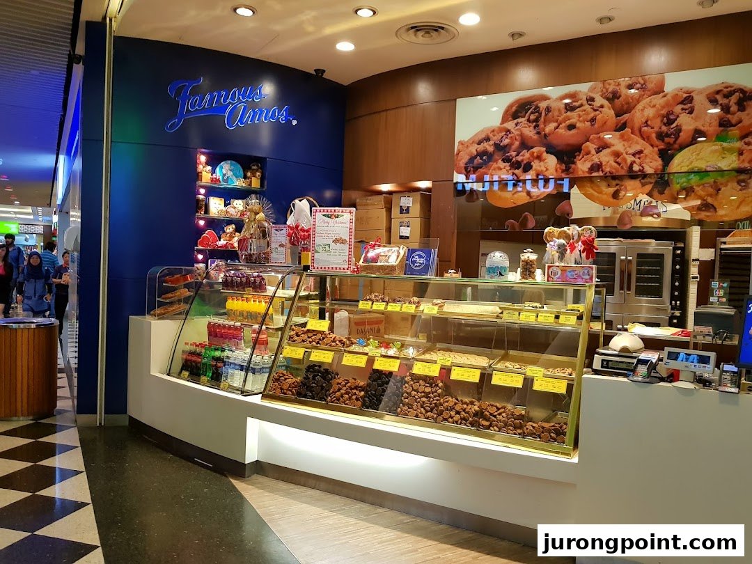 A vibrant Famous Amos cookie shop entrance showcasing fresh cookies and festive displays.
