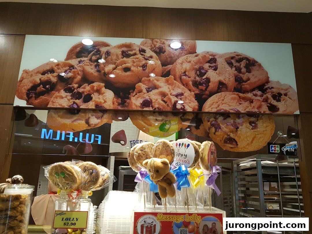 A vibrant display of Famous Amos cookies and lollipops, featuring a large graphic of chocolate chip cookies.