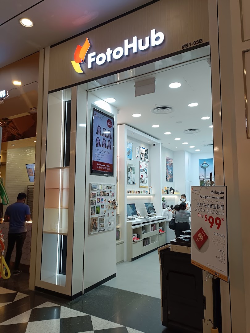 The brightly lit entrance of FotoHub, a photography service shop, featuring a Malaysia Passport Renewal promotion.