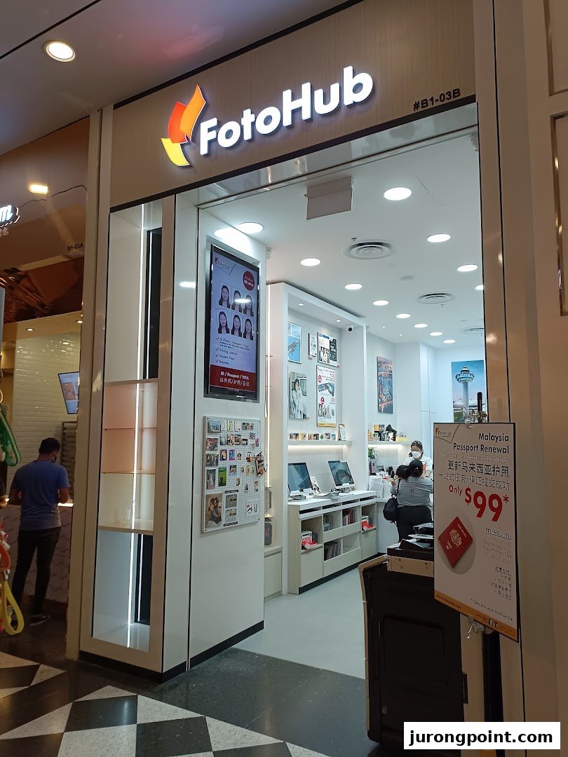 The brightly lit entrance of FotoHub, a photography service shop, featuring a Malaysia Passport Renewal promotion.