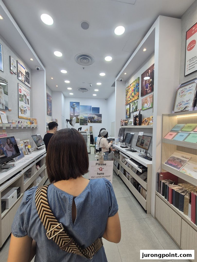 Interior view of FotoHub, showcasing photo printing stations, personalized products, and customers browsing.