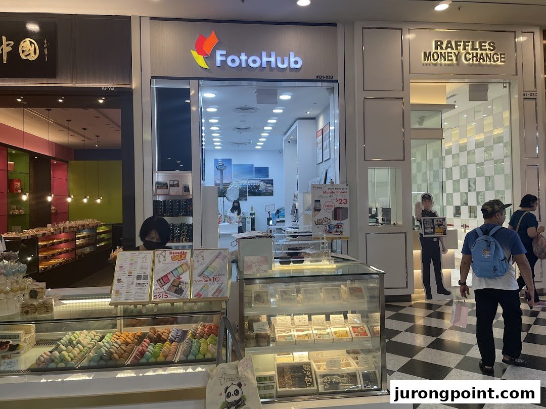 The storefront of FotoHub, a photo printing and mobile accessories shop, within a bustling mall.