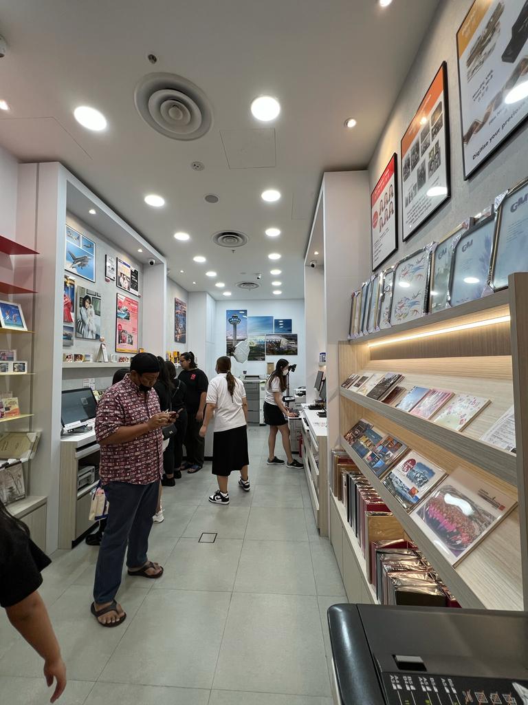 Interior view of FotoHub, a photo printing and imaging services shop, with customers and displays.