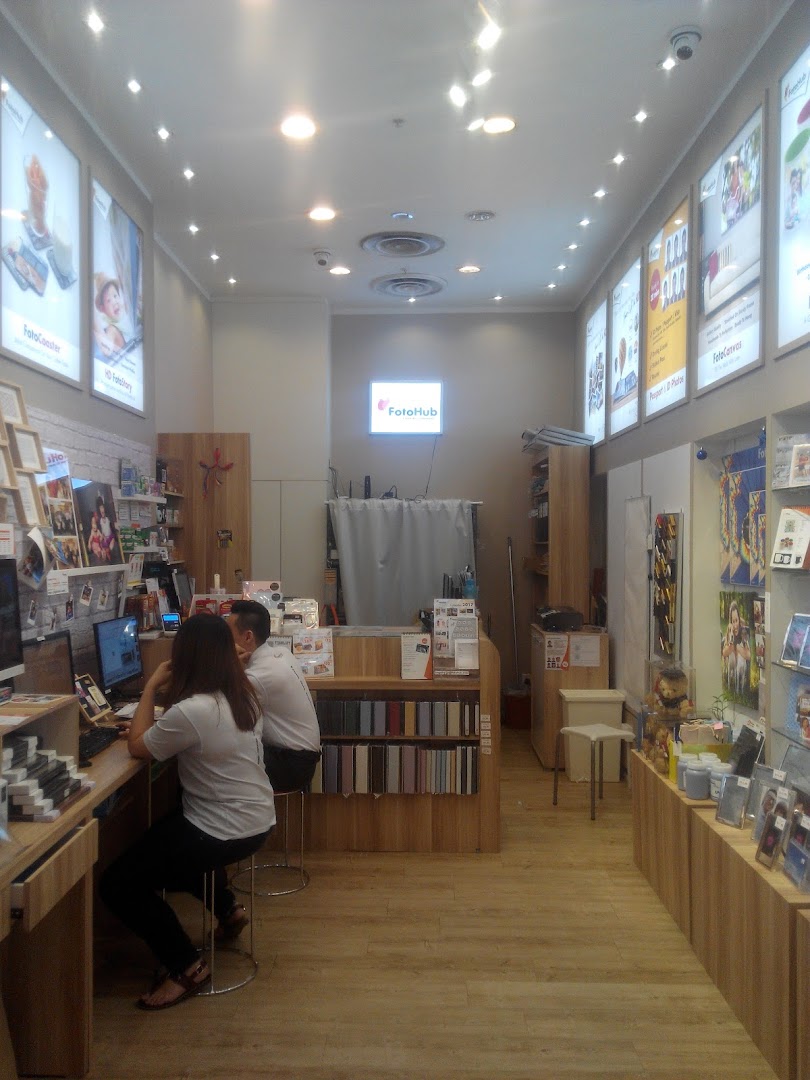 Interior view of FotoHub, a photo printing shop, with staff assisting customers.