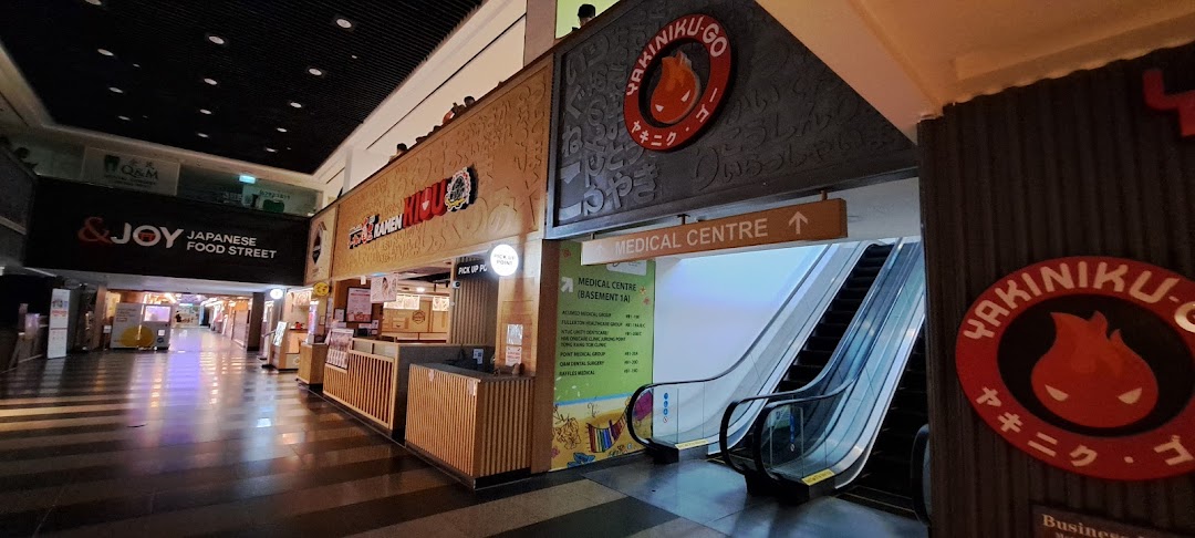 A mall corridor featuring Japanese food stalls and a directional sign to the Medical Centre, including Fullerton Health.