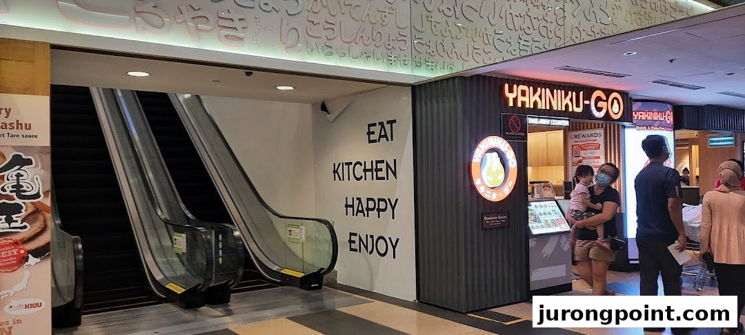 The entrance of Yakiniku-Go restaurant in a mall, featuring escalators and inviting signage.