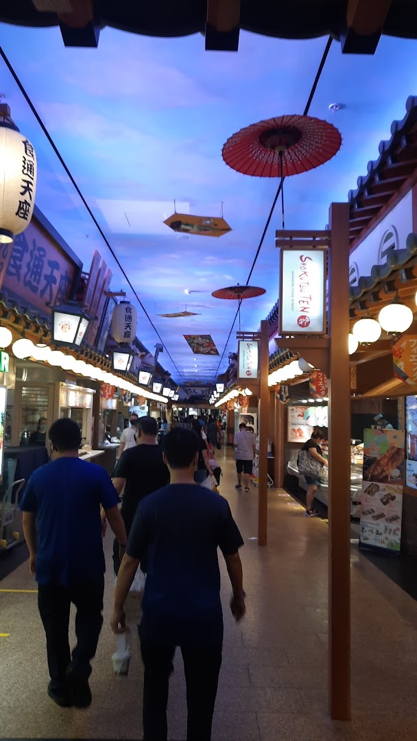 A vibrant Japanese-themed food street bustling with visitors exploring various eateries.
