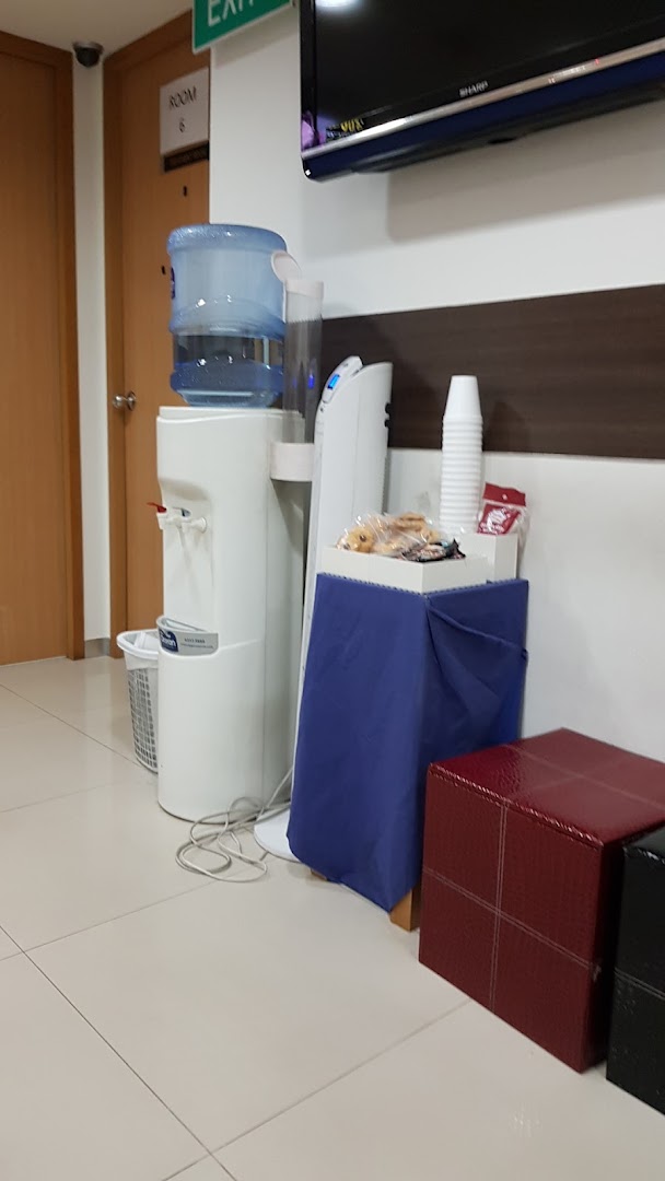 A waiting area with a water dispenser, snacks, and seating at Fullerton Health.