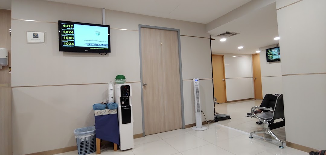 A clean and modern waiting area at Fullerton Health, featuring a queue display and water dispenser.