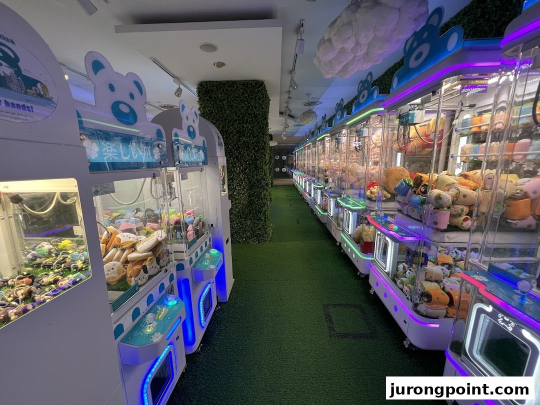A vibrant interior view of Fun Claw, showcasing a long aisle of brightly lit claw machines filled with prizes.