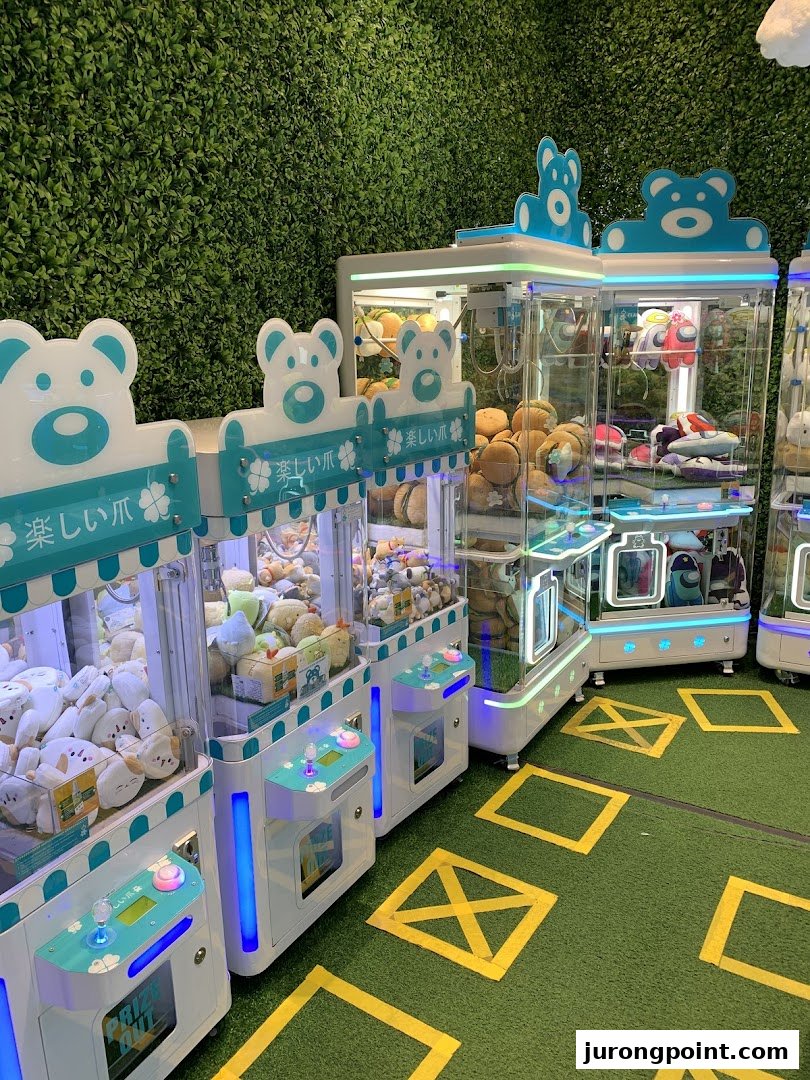 Multiple brightly lit claw machines filled with plush toys and prizes inside Fun Claw.