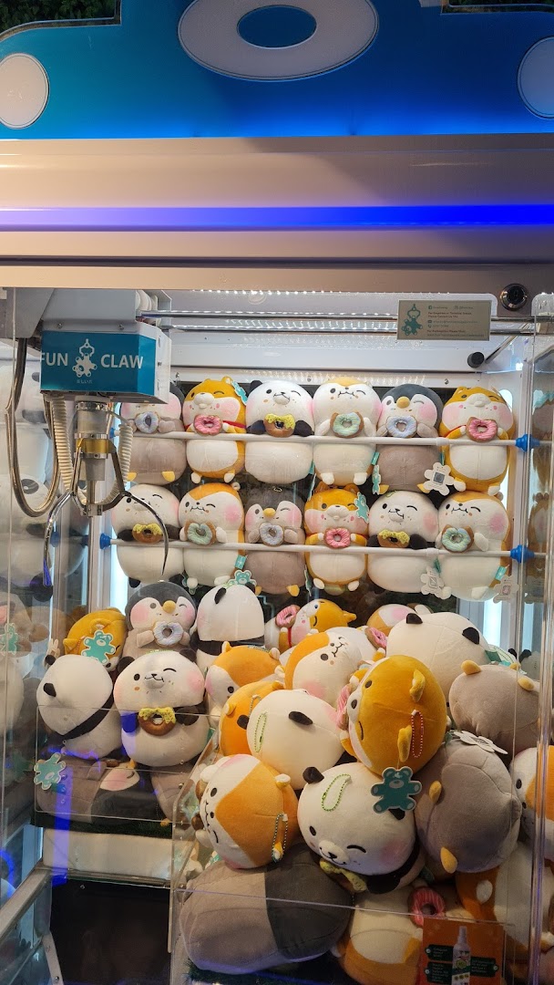 A claw machine filled with adorable, donut-holding plush toys from Fun Claw.