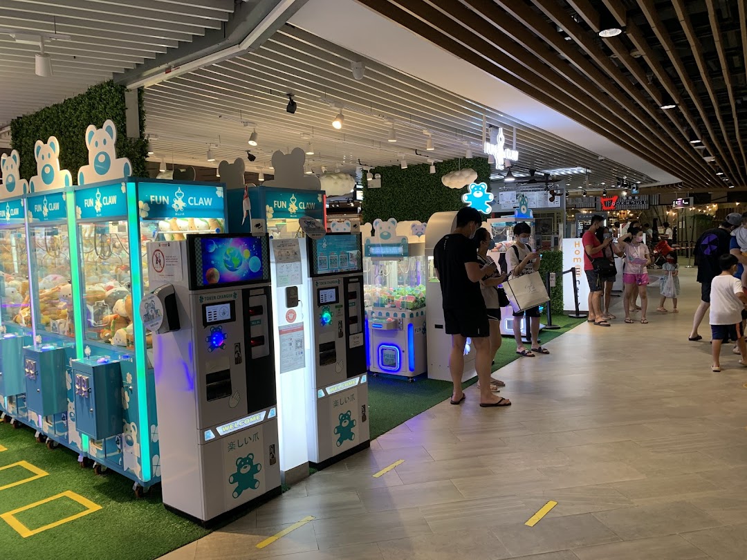 Customers enjoy playing various claw machine games at Fun Claw, featuring token changers and plush toys.