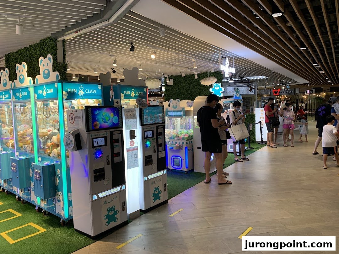 Customers enjoy playing various claw machine games at Fun Claw, featuring token changers and plush toys.