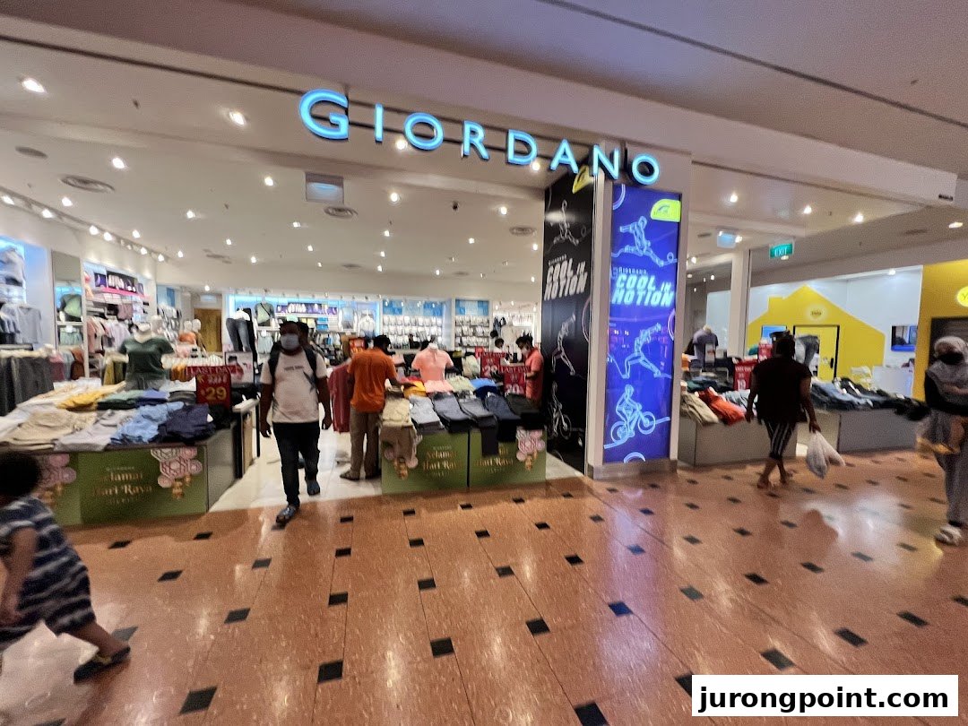 The Giordano shop entrance features clothing displays, promotional signage, and shoppers browsing inside.