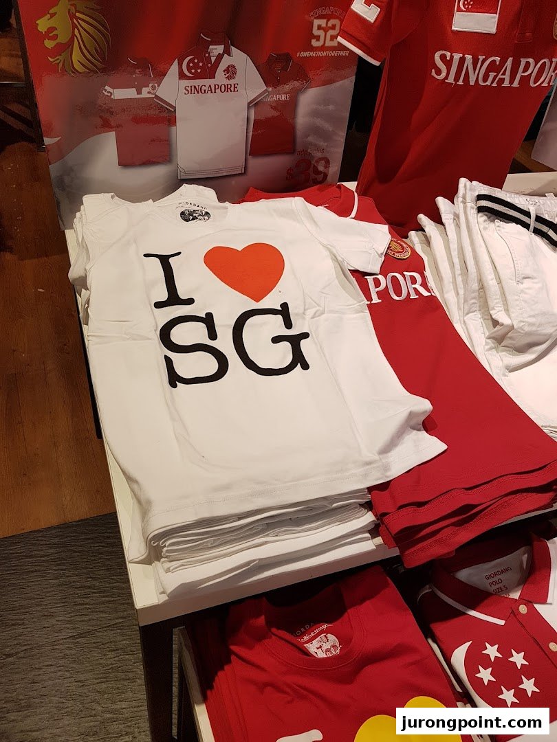 A display of Singapore-themed apparel, including 'I ❤️ SG' t-shirts and red polo shirts, inside Giordano.