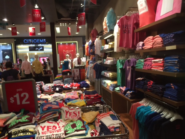 Vibrant interior of Giordano showcasing a wide array of colorful apparel, including polo shirts for $12.