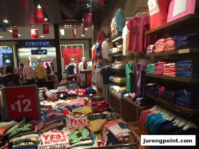 Vibrant interior of Giordano showcasing a wide array of colorful apparel, including polo shirts for $12.