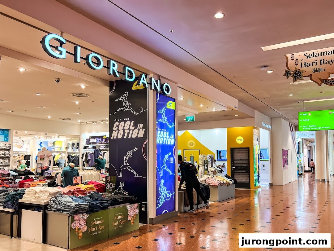 The Giordano shop entrance in a mall, showcasing clothing displays and 'Cool in Motion' signage.