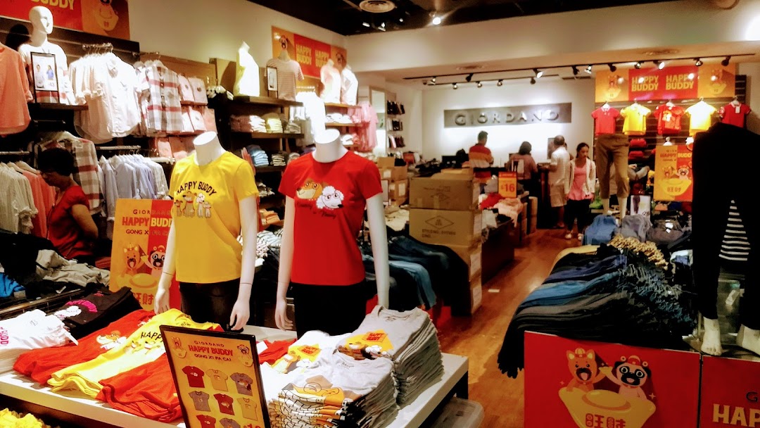 Interior view of a Giordano clothing store, featuring mannequins displaying casual wear and racks of apparel.