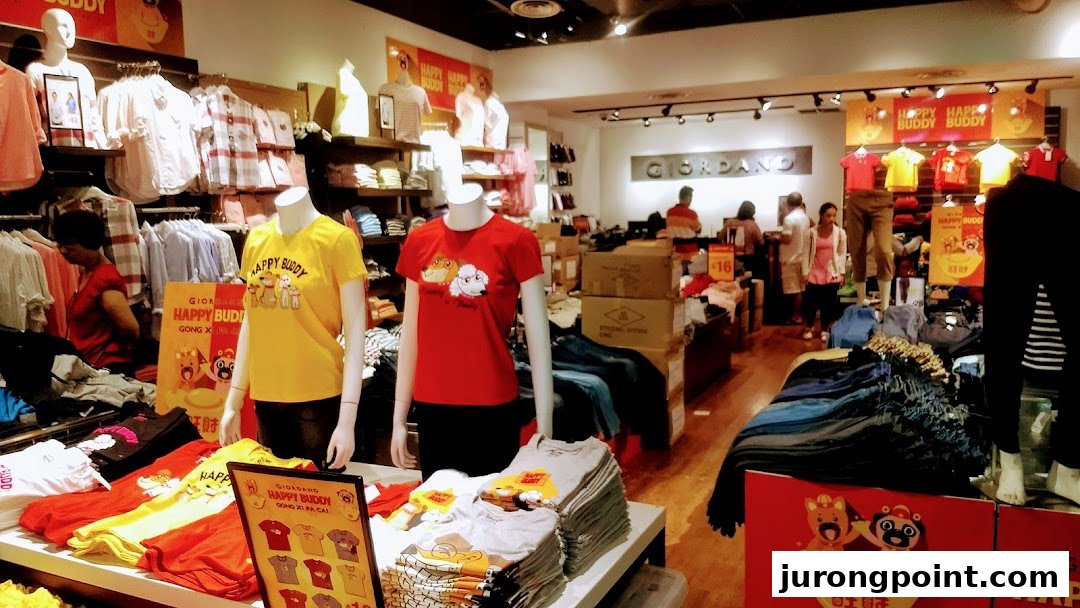 Interior view of a Giordano clothing store, featuring mannequins displaying casual wear and racks of apparel.