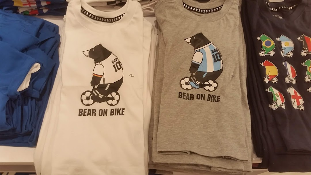 Close-up of Giordano's 'Bear on Bike' graphic t-shirts featuring various national team designs.