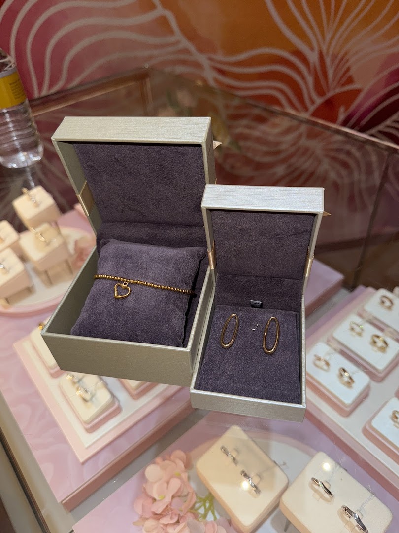Close-up of a Goldheart Jewelry display featuring a heart bracelet and oval earrings in open boxes.