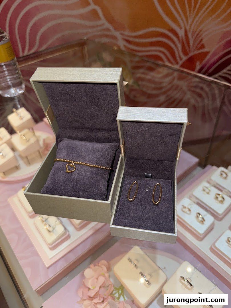 Close-up of a Goldheart Jewelry display featuring a heart bracelet and oval earrings in open boxes.