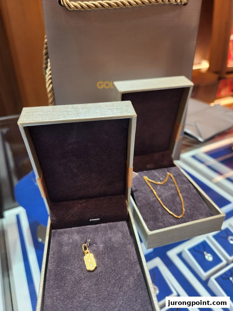 Close-up of Goldheart jewelry boxes displaying a gold pendant and chain.