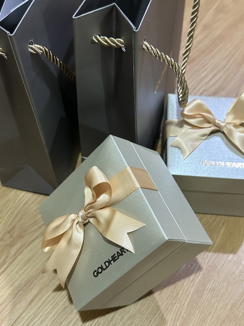 Elegant Goldheart Jewelry gift boxes and shopping bags with golden ribbons.