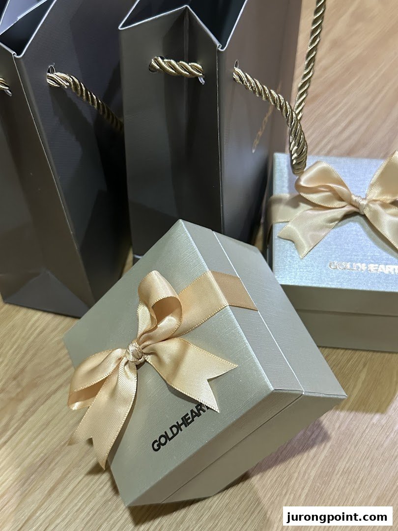 Elegant Goldheart Jewelry gift boxes and shopping bags with golden ribbons.