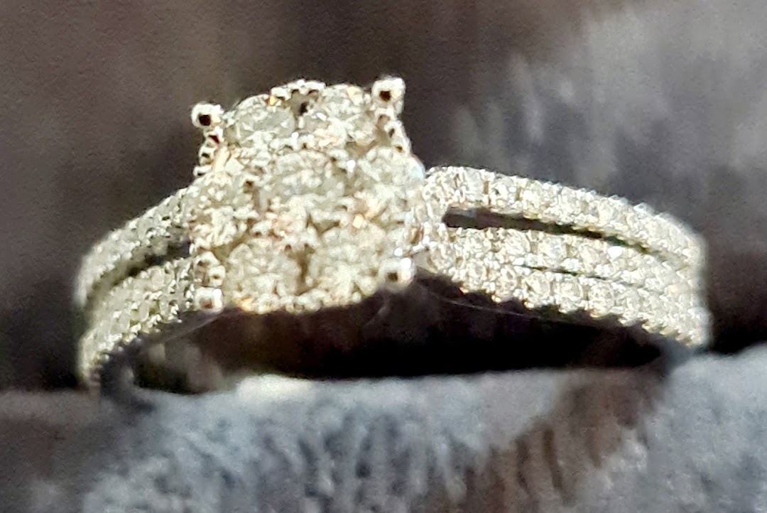 A close-up of a sparkling diamond ring featuring a cluster center and pavé-set band.