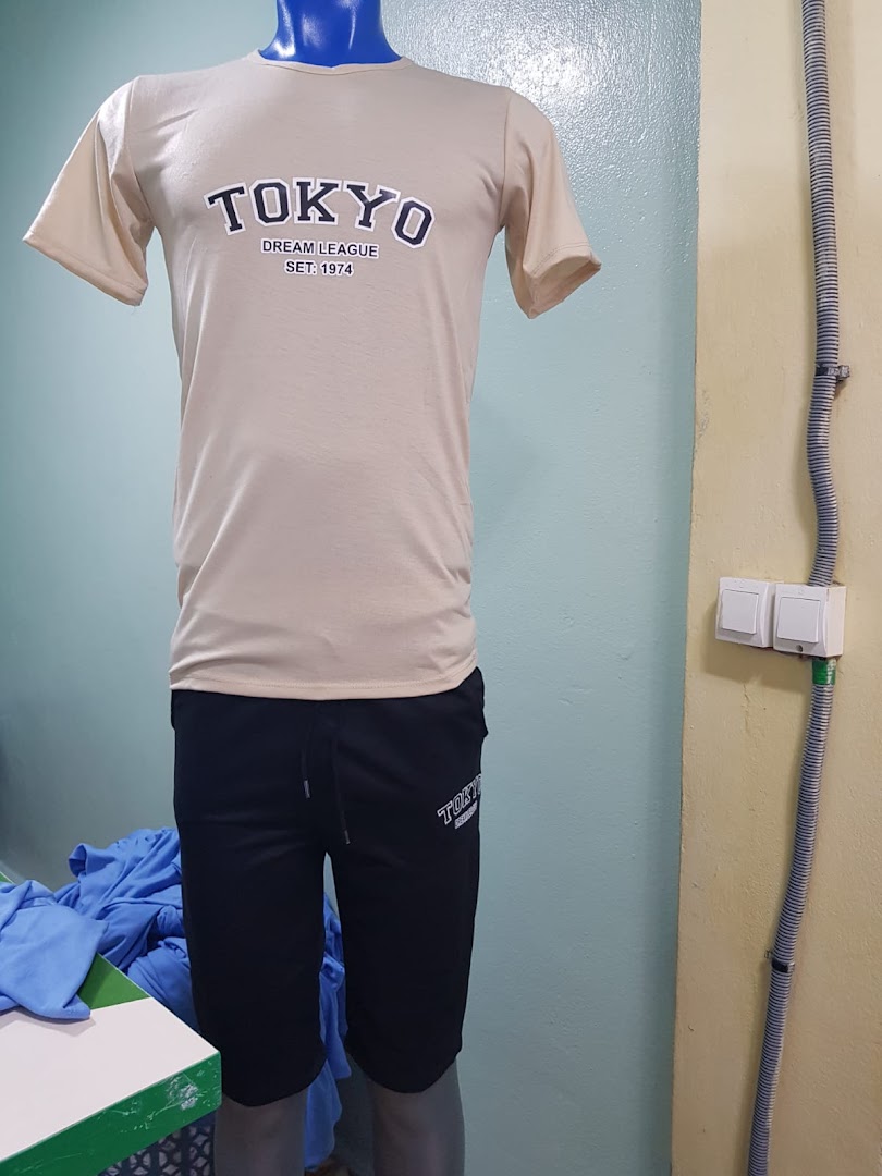 Mannequin displays a beige t-shirt with 'TOKYO' print and black shorts inside a retail shop.